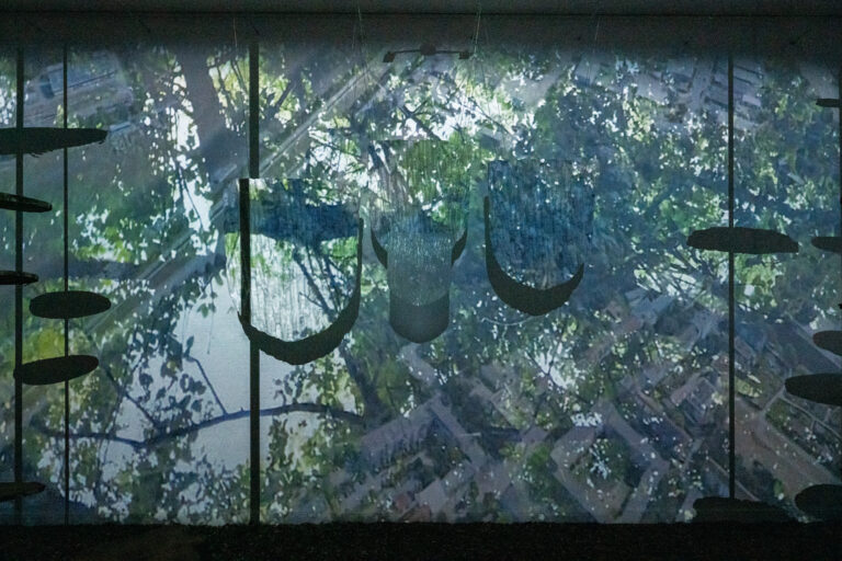 Exhibition view: hanging sculptures with tree bark pattern